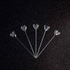 Sparkling silver heart cocktail sticks for elegant entertaining and fancy drinks, ideal for parties and special occasions.