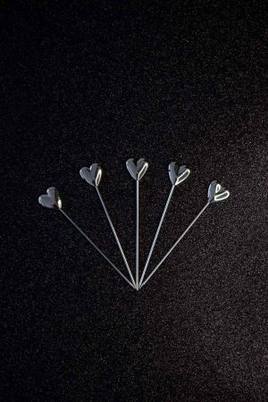 Sparkling silver heart cocktail sticks for elegant entertaining and fancy drinks, ideal for parties and special occasions.